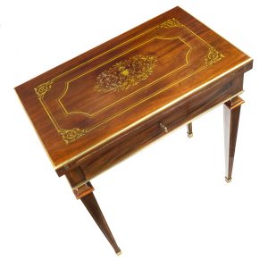 A French Empire mahogany combination table, finely inlaid with brass